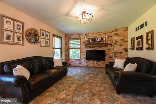 12 Ethan Ter, Woolwich Twp, NJ 08085 - living room with stone finish flooring, a chandelier, a fireplace, and brick wall