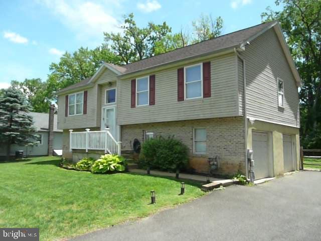 2602 Avenue E Ave E, Levittown, PA 19056 - raised ranch with driveway, a front lawn, brick siding, and a garage