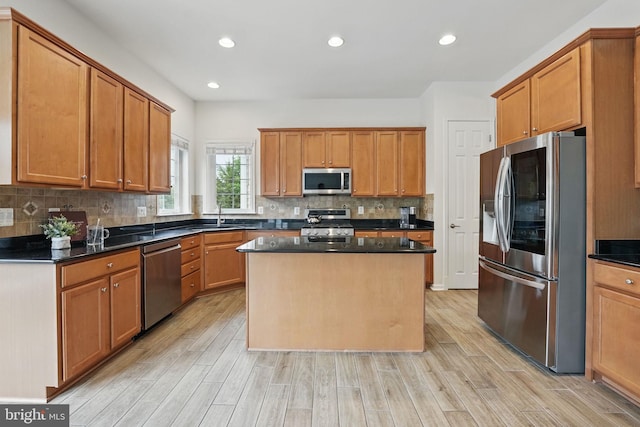 8313 Middle Ruddings Dr, Lorton, VA 22079 - kitchen with stainless steel appliances, dark countertops, light wood finished floors, a kitchen island, and decorative backsplash