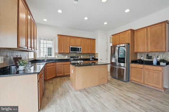 8313 Middle Ruddings Dr, Lorton, VA 22079 - kitchen featuring appliances with stainless steel finishes, decorative backsplash, dark countertops, a sink, and a kitchen island