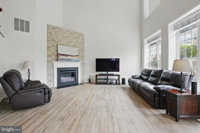 8313 Middle Ruddings Dr, Lorton, VA 22079 - living area with a towering ceiling, light wood-style floors, and a fireplace with flush hearth