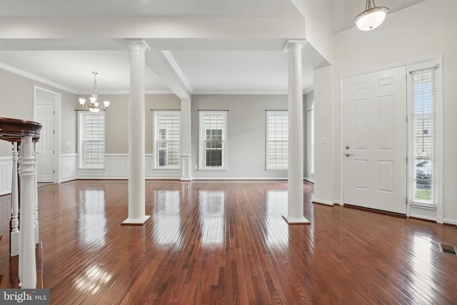 8313 Middle Ruddings Dr, Lorton, VA 22079 - entryway with decorative columns, wood-type flooring, a chandelier, a wainscoted wall, and ornamental molding