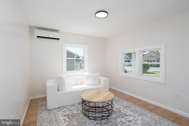 511 Goldsborough Ave, Cambridge, MD 21613 - living area featuring a wall unit AC, healthy amount of natural light, wood finished floors, and baseboards