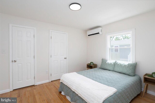 511 Goldsborough Ave, Cambridge, MD 21613 - bedroom with a wall mounted AC, light wood-style floors, and baseboards