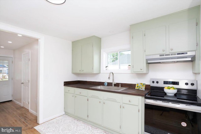 511 Goldsborough Ave, Cambridge, MD 21613 - kitchen with stainless steel electric stove, under cabinet range hood, a sink, dark countertops, and recessed lighting