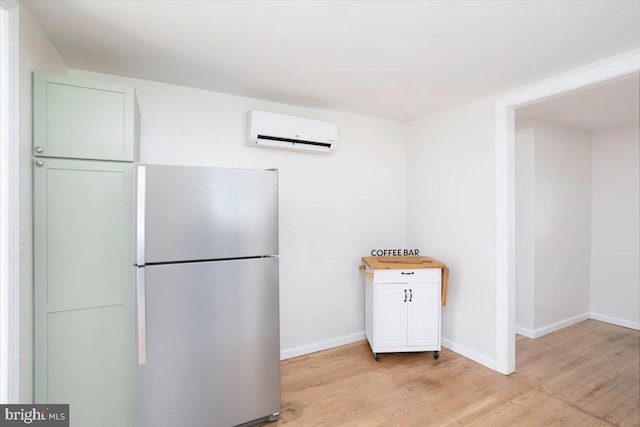 511 Goldsborough Ave, Cambridge, MD 21613 - kitchen featuring an AC wall unit, freestanding refrigerator, light wood-type flooring, and baseboards