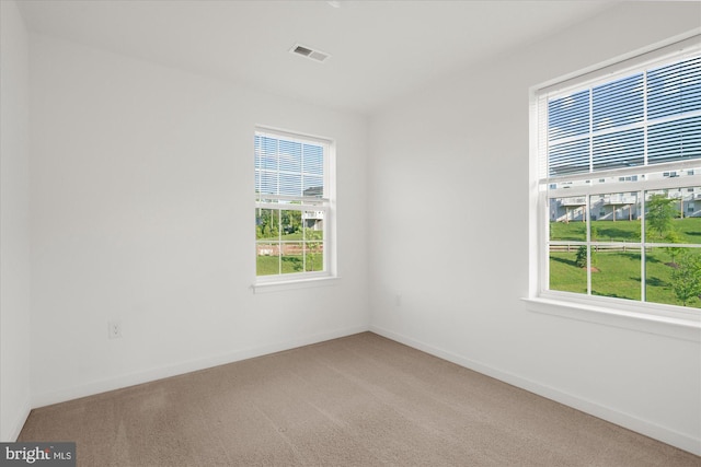 spare room with light carpet and baseboards