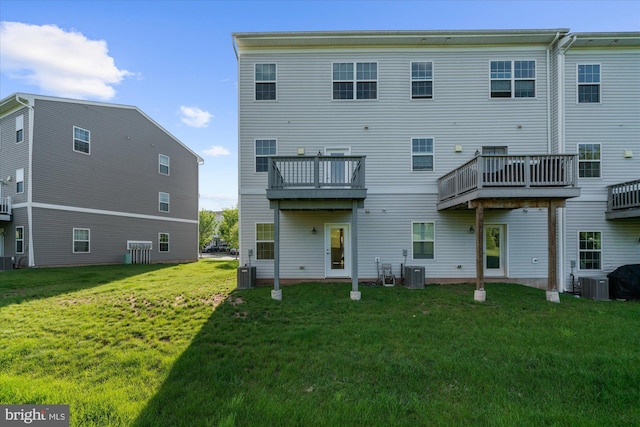 rear view of house featuring central AC and a lawn