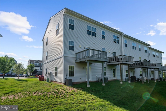 rear view of house featuring a lawn, central AC, and a deck