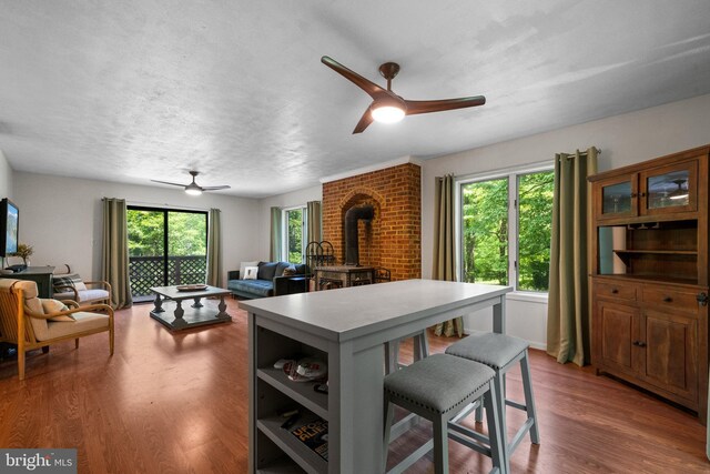 448 Newton Dr, Linden, VA 22642 - kitchen featuring ceiling fan, a wood stove, a breakfast bar area, and wood finished floors