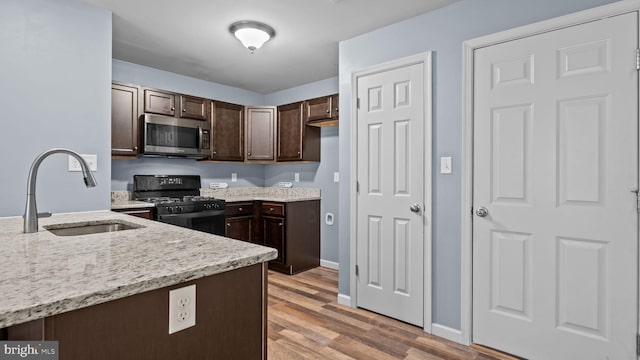 3073 Goshen Dr Unit M55L, Pennsburg, PA 18073 - kitchen with stainless steel microwave, black gas range, a sink, dark brown cabinetry, and light stone countertops