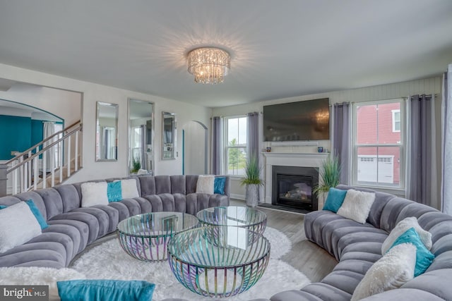 878 Sweet Birch Dr, Middletown, DE 19709 - living area with wood finished floors, a chandelier, a glass covered fireplace, and stairway