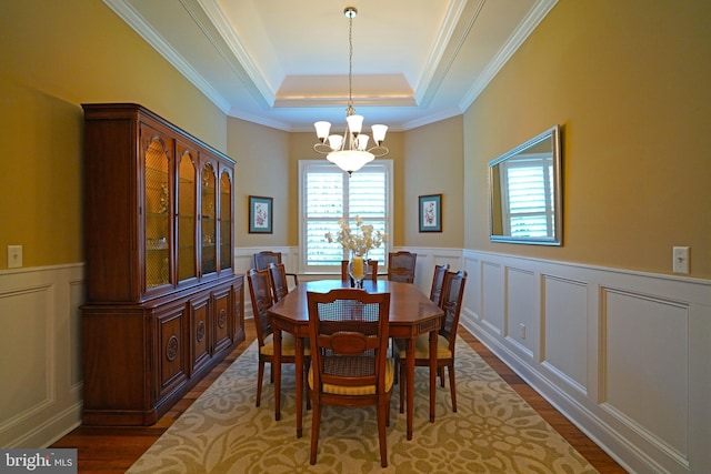 322 Captains Cir, Lewes, DE 19958 - dining room featuring a chandelier, a tray ceiling, a decorative wall, dark wood-type flooring, and a wainscoted wall