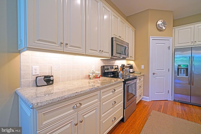 322 Captains Cir, Lewes, DE 19958 - kitchen featuring stainless steel appliances, light wood-style flooring, white cabinetry, decorative backsplash, and light stone counters