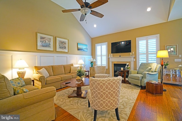 322 Captains Cir, Lewes, DE 19958 - living room with high vaulted ceiling, a ceiling fan, plenty of natural light, a glass covered fireplace, and wood finished floors