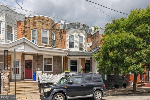 3164 Cedar St, Philadelphia, PA 19134 - view of property featuring stone siding, cooling unit, and covered porch