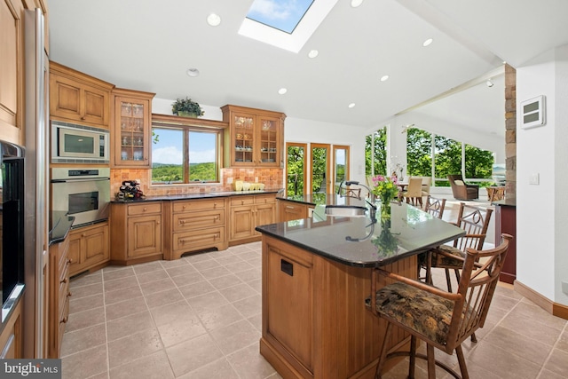 511 Center Hl, Upper Black Eddy, PA 18972 - kitchen featuring stainless steel appliances, a breakfast bar, tasteful backsplash, a sink, and a skylight
