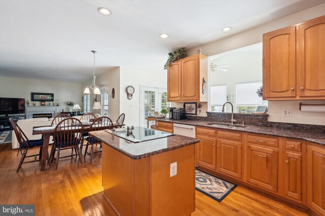 19655 Smith Cir, Ashburn, VA 20147 - kitchen with a sink, electric stovetop, a center island, light wood-type flooring, and a fireplace