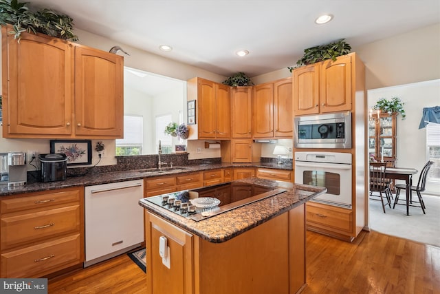 19655 Smith Cir, Ashburn, VA 20147 - kitchen featuring white appliances, a sink, a center island, light wood finished floors, and dark stone countertops