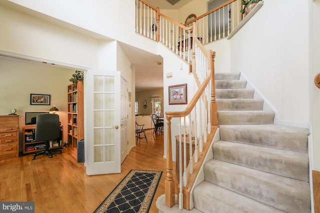 19655 Smith Cir, Ashburn, VA 20147 - stairs featuring wood finished floors, a towering ceiling, and french doors