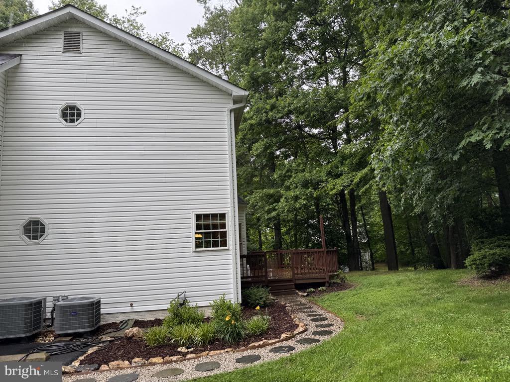 6051 Whippoorwill Dr, Warrenton, VA 20187 - view of property exterior with central AC unit, a wooden deck, and a lawn