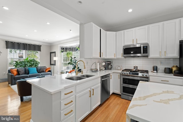 7424 Serenade Cir, Clinton, MD 20735 - kitchen featuring appliances with stainless steel finishes, a sink, a peninsula, light wood-type flooring, and open floor plan