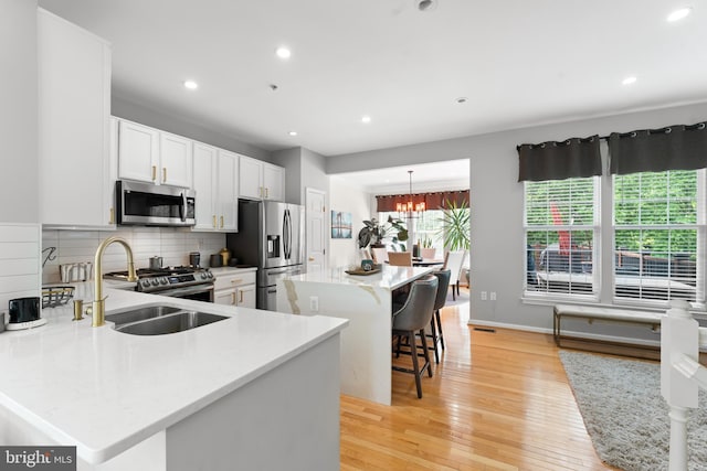 7424 Serenade Cir, Clinton, MD 20735 - kitchen with stainless steel appliances, a center island, light wood-style flooring, tasteful backsplash, and a kitchen bar