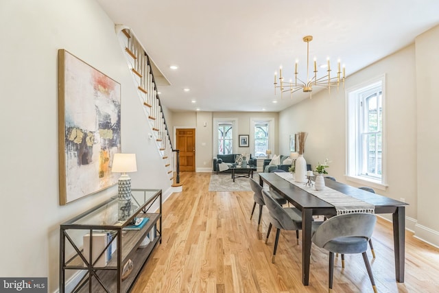 dining area with light wood-type flooring, stairs, recessed lighting, a chandelier, and baseboards