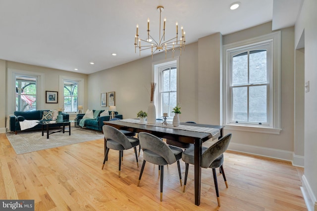 dining room featuring light wood-style floors, recessed lighting, baseboards, and a chandelier