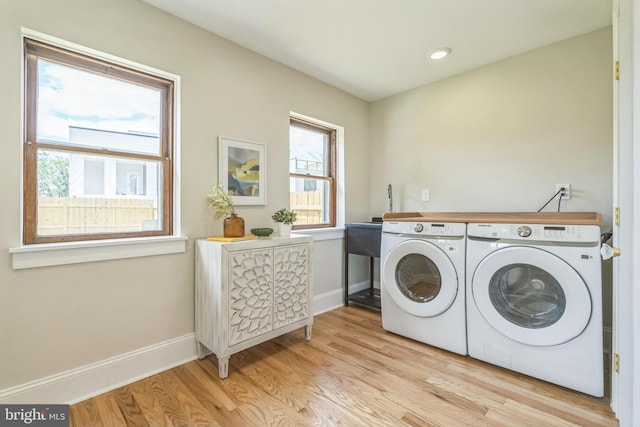 washroom with washing machine and clothes dryer, light wood-style floors, baseboards, and recessed lighting