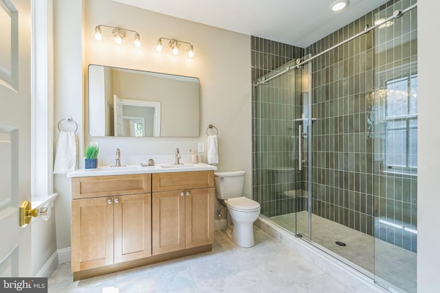 bathroom with toilet, a tile shower, baseboards, double vanity, and tile patterned floors