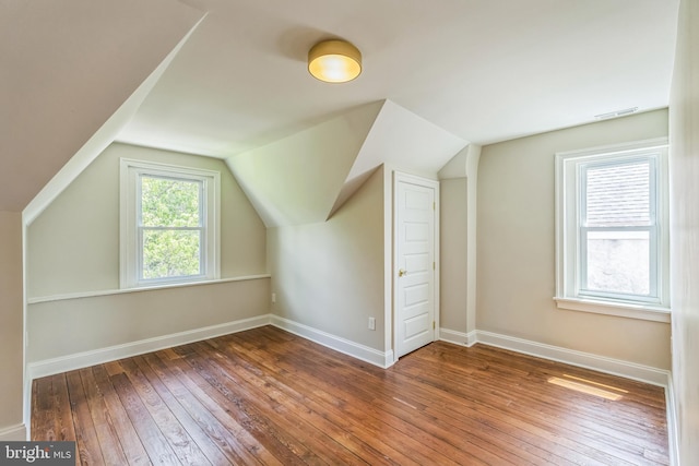 bonus room featuring wood-type flooring, baseboards, and vaulted ceiling