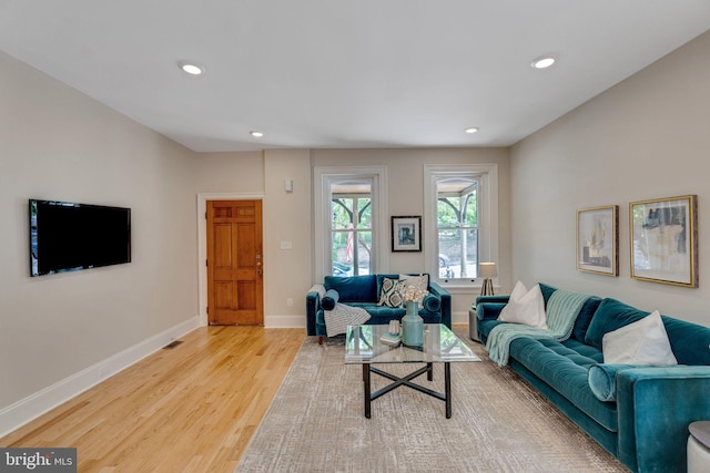 living room featuring wood finished floors, recessed lighting, and baseboards