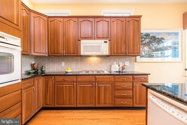 39 Nathaniel, Holland, PA 18966 - kitchen with white appliances, light wood-style flooring, dark stone countertops, and decorative backsplash