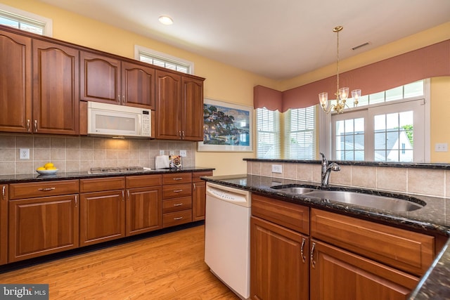 39 Nathaniel, Holland, PA 18966 - kitchen featuring white appliances, a sink, dark stone countertops, a chandelier, and decorative light fixtures