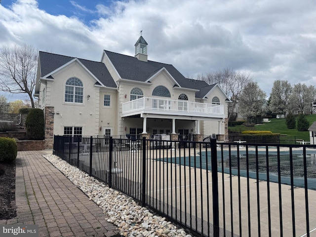 39 Nathaniel, Holland, PA 18966 - rear view of house with a balcony, a patio, stone siding, and stucco siding