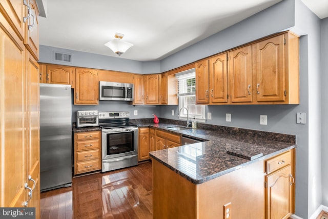 12125 Gatewater Dr, Potomac, MD 20854 - kitchen featuring appliances with stainless steel finishes, a sink, dark wood finished floors, a peninsula, and dark stone counters