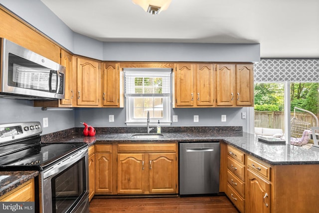 12125 Gatewater Dr, Potomac, MD 20854 - kitchen featuring appliances with stainless steel finishes, a sink, a peninsula, dark wood finished floors, and dark stone counters