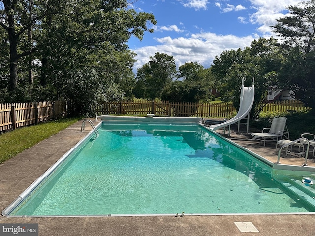 1103 Waugh Rd, Berkeley Springs, WV 25411 - view of pool with a water slide, a fenced backyard, view of scattered trees, and a patio