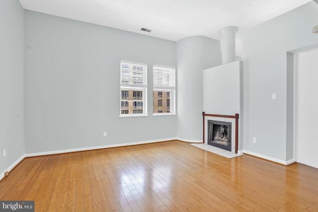 2114 N St NW Unit 46, Washington, DC 20037 - unfurnished living room with wood-type flooring, a tile fireplace, and baseboards
