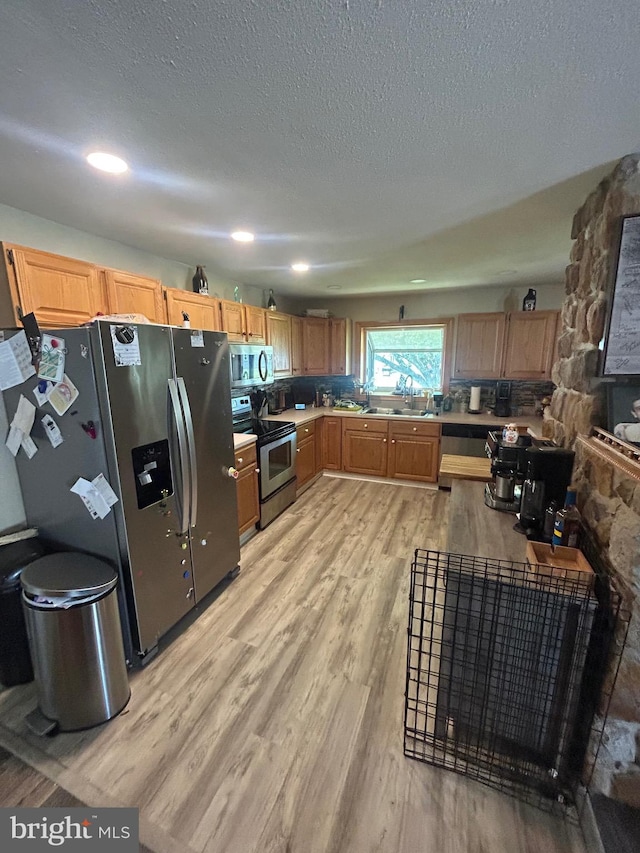 44 Sugarmaple Ln, Levittown, PA 19055 - kitchen featuring stainless steel appliances, light wood finished floors, a sink, a textured ceiling, and light countertops