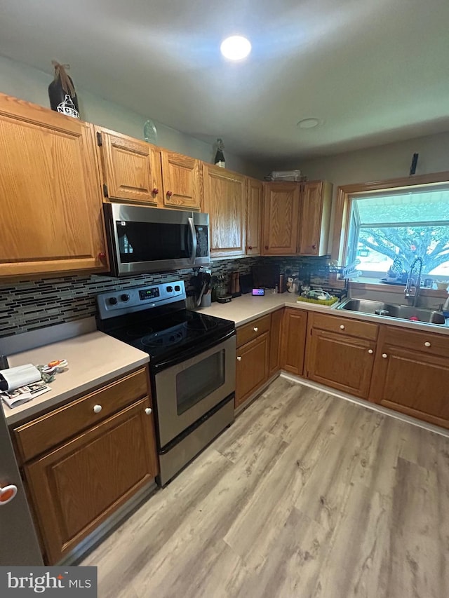44 Sugarmaple Ln, Levittown, PA 19055 - kitchen with stainless steel appliances, a sink, backsplash, light wood-style floors, and light countertops