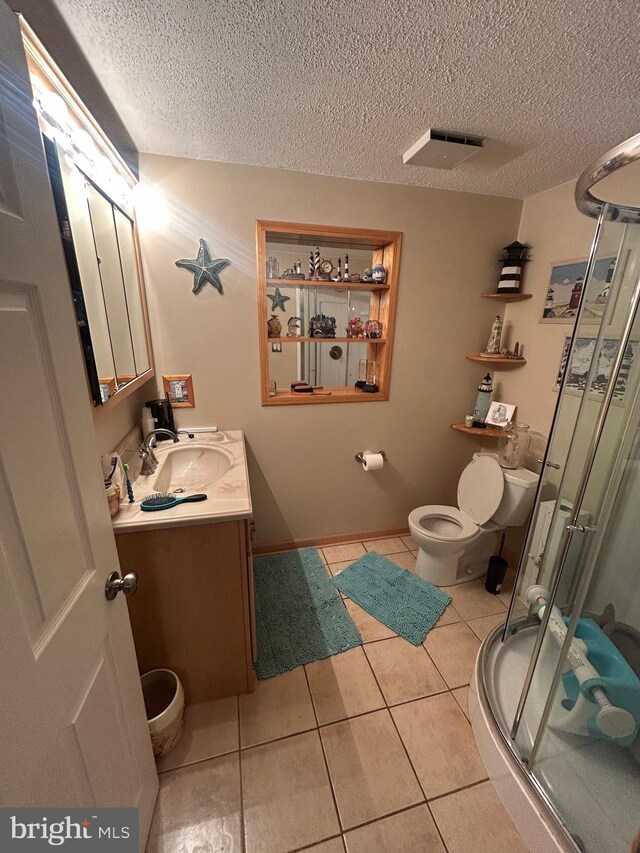 44 Sugarmaple Ln, Levittown, PA 19055 - bathroom featuring toilet, vanity, tile patterned floors, a stall shower, and a textured ceiling