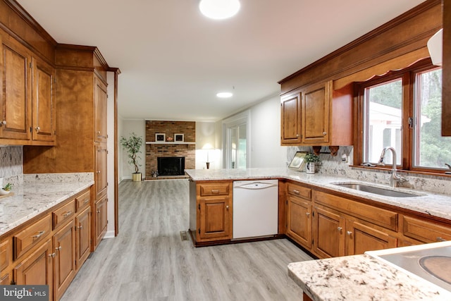 5183 Silver Run Ln, Salisbury, MD 21801 - kitchen with dishwasher, a sink, light wood-style floors, brown cabinets, and a brick fireplace