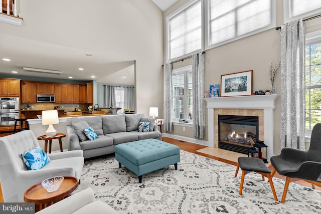 8 Warwick Ct, Newtown, PA 18940 - living area with recessed lighting, a towering ceiling, a tile fireplace, baseboards, and wood finished floors