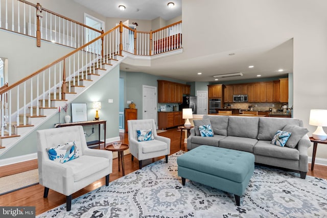 8 Warwick Ct, Newtown, PA 18940 - living area featuring baseboards, light wood-style flooring, a towering ceiling, and recessed lighting