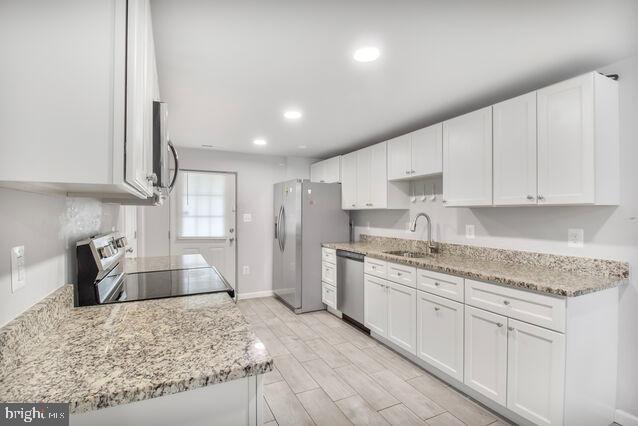 107 Main Ave SW, Glen Burnie, MD 21061 - kitchen with a sink, stainless steel appliances, white cabinets, recessed lighting, and light stone counters