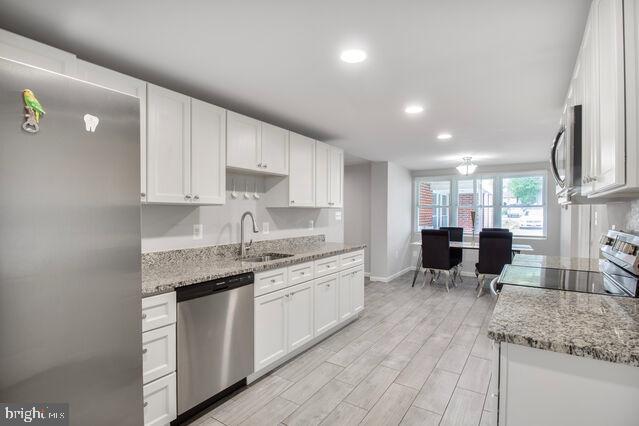 107 Main Ave SW, Glen Burnie, MD 21061 - kitchen with stainless steel appliances, a sink, white cabinetry, recessed lighting, and baseboards
