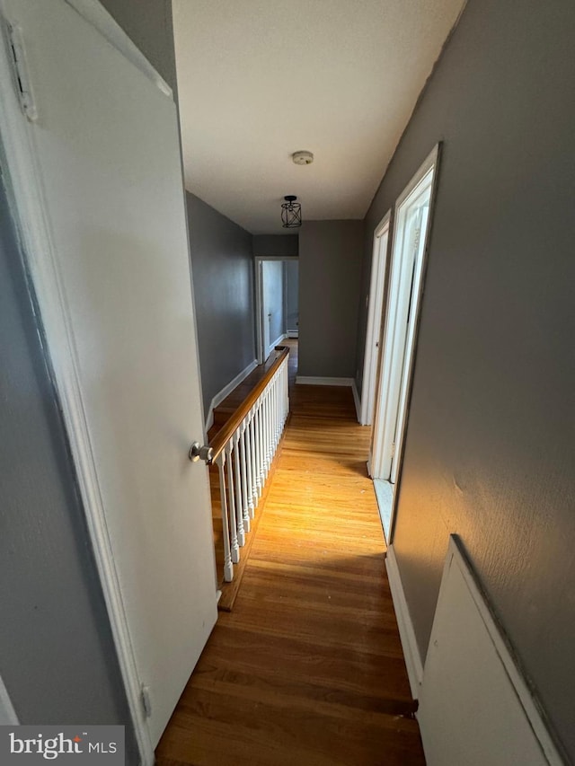 hallway featuring wood finished floors and baseboards
