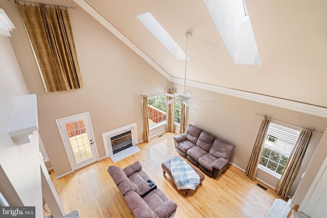 20245 Ordinary Pl, Ashburn, VA 20147 - living room featuring a skylight, light wood-type flooring, a fireplace, and high vaulted ceiling